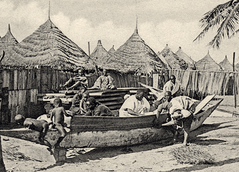 Sur cette pirogue en construction, deux hommes s’emploient à coudre un bordage avec une cordelette passée dans chaque trou à l’aide d’une aiguille.