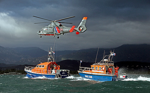 deux bateaux snsm et hélicoptère