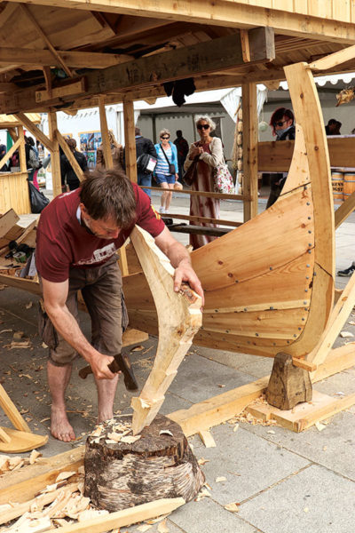 à la Semaine du Golfe 2019, à Vannes, un charpentier construit un ranværing norvégien. L’animation du port, pendant que les bateaux naviguent au dehors est un des enjeux de l’organisation des fêtes. 