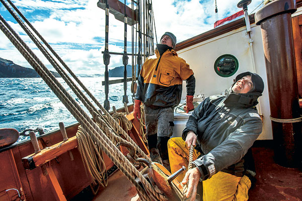 Le capitaine Maarten de Jong règle la grand-voile, sous l’œil d’un matelot, Ben Bolt, dans le canal de Beagle.