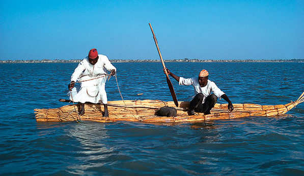 Deux Buduma pêchent depuis un radeau de roseaux .
