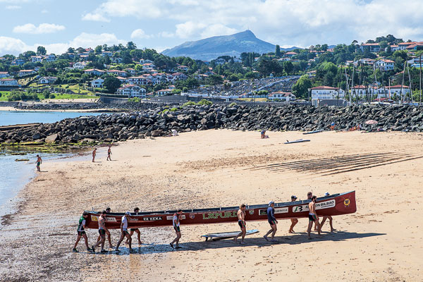 sur la plage de Ciboure, les rameurs du lat portent leur traînière hors de l’eau après l’entraînement.