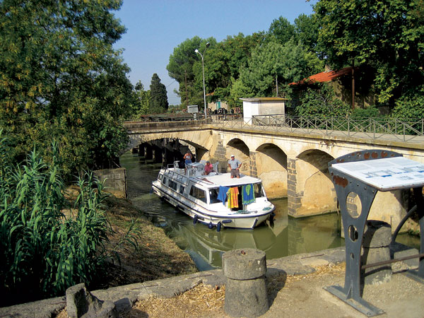 Un bateau venant de Béziers traverse l’ouvrage du Libron