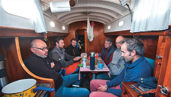 Une fois les bateaux rangés, tout le monde se retrouve dans le chaleureux carré de Marike, à Paskal Morvan, qu’on reconnaît à droite, à côté de son frère Erwan. 