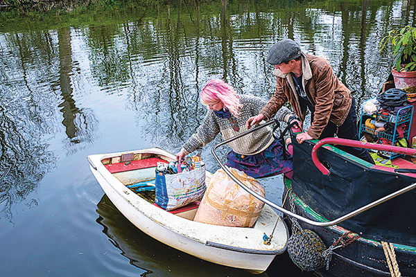 Couple qui passent les poubelles sur l'annexe de leur narrowboat