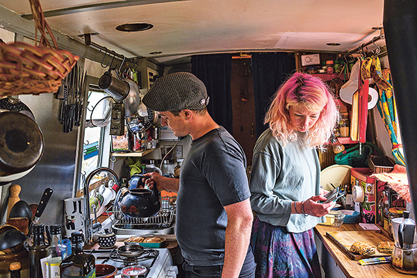 Un couple dans la cuisine, à bord d'un narrowboat.