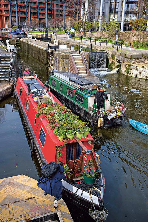 Deux narrowboats prennent une écluse.