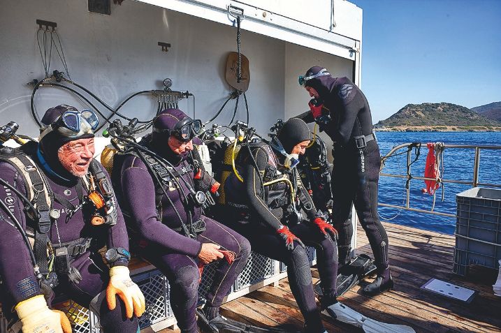 4 plongeurs sur un bateau quelques minutes avant une expédition sous-marine. 