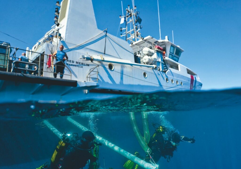 Photo du bateau, l'Alfred Merlin et de ses équipements manipulés sous l'eau par les plongeurs.