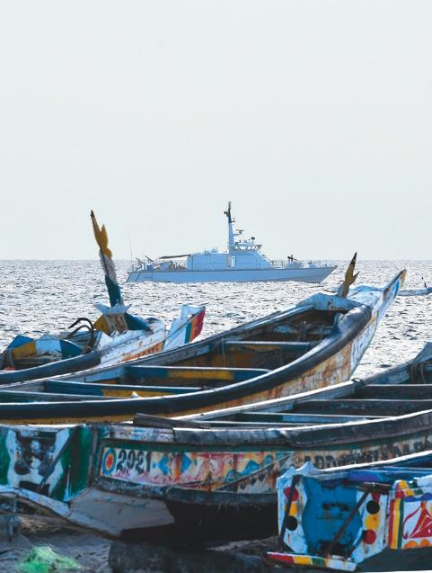 Quatre ancien bateau en bois, à quai, face à patrouilleur, lui, en mer.