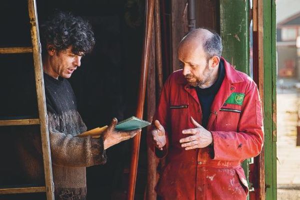 Deux personnes discutant à l'entrée de l'entrepôt.