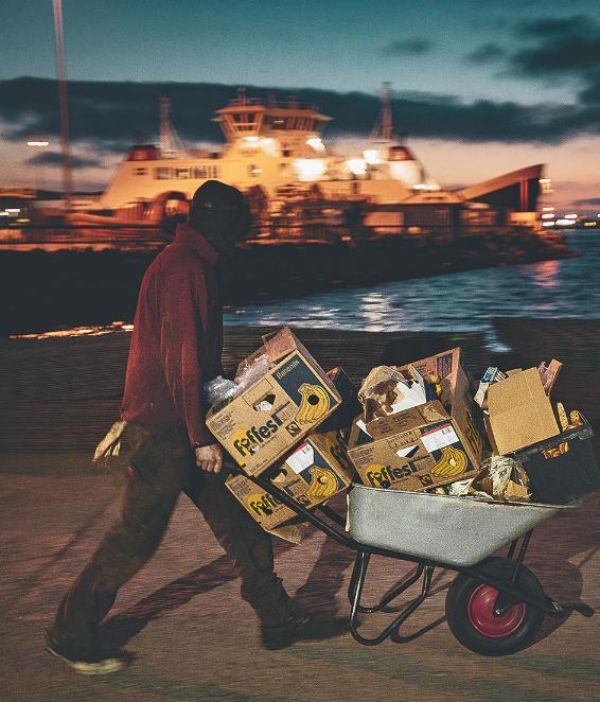 Ouvrier sur le port, transportant du matériel dans une brouette.