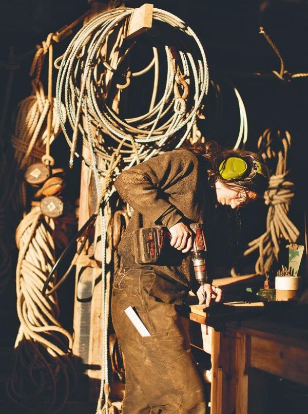 Ouvrier travaillant le bois sur un plan de travail.