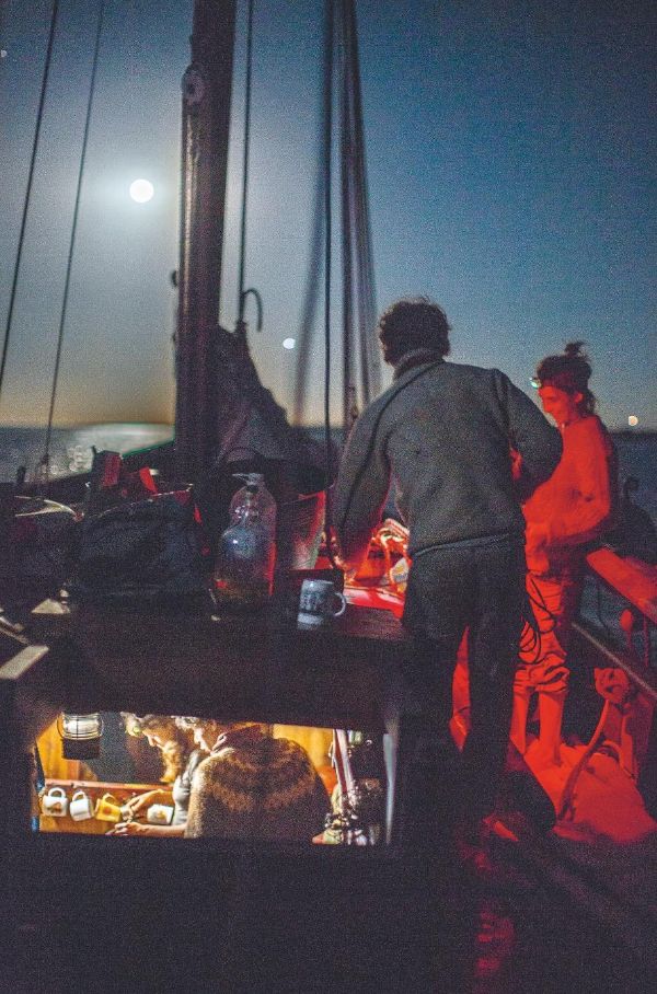 Plusieurs membre de l'équipage sur le bateau en mer, de nuit.