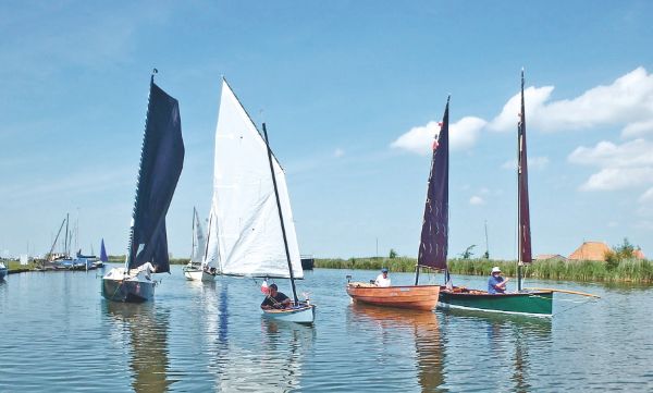 Cinq bateaux, traversant un lac.