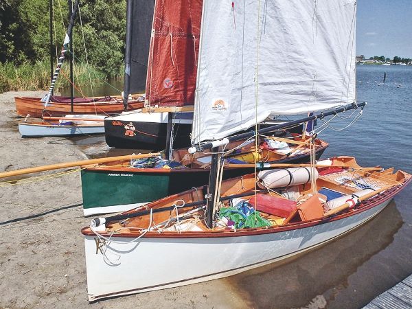 5 bateaux en bois, sortant de l'au à quai.