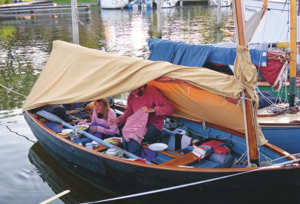 Deux personne sur un bateau avec une toile en coton en guise de tente.