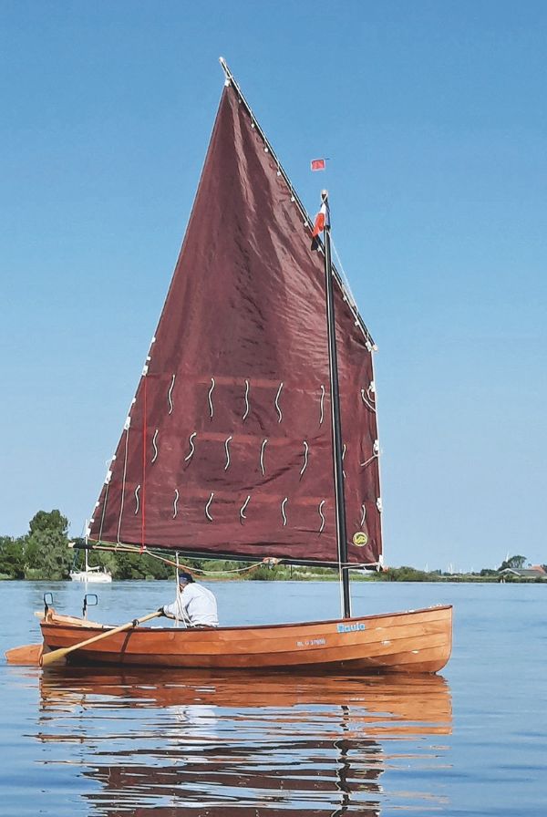 Photo d'un bateau à voile rouge, en mer.