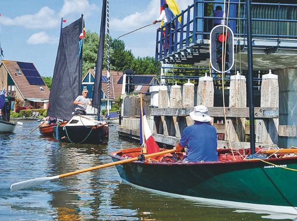 Trois bateaux se rapprochant d'un port.