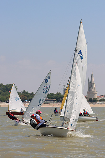 Les 1er et 2 juillet derniers, La Rochelle a accueilli les épreuves du trophée Michel Rouillé. Dans le sillage du 420, on reconnaît un Moth Europe (à gauche)  et un Zef (à droite). 
En second rideau,  
le Dinghy 12 Lord Jim et, avec sa voile jaune, une réplique de houari nantais, construit en 1999 par Didier Léveillé, l’Atypique Houari 
de Montretraict. © Mélanie Joubert