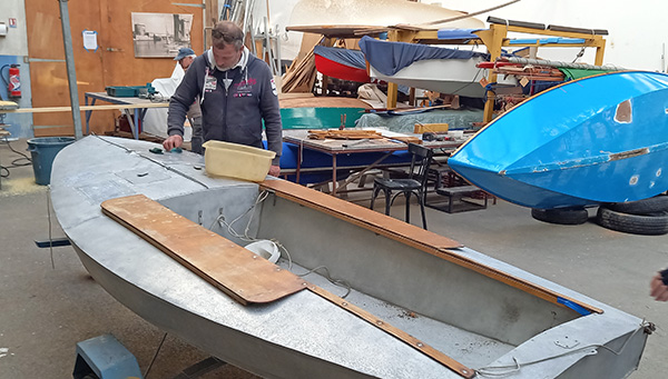 Dans l’atelier des Amis, les tâches ne manquent pas. On voit ici un adhérent au chevet du Moth en aluminium N’oublie jamais, « Gouget » – du nom  de son architecte – dont le premier exemplaire est sorti en 1948. © Association des Amis du Musée maritime de La Rochelle