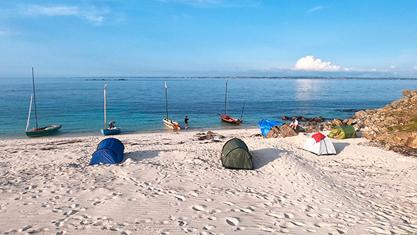 Au terme de la première journée de navigation, la flottille s’installe  
sur la plage de Ledenez, à Quéménès, pour y passer la nuit.  La pleine mer étant tôt le lendemain, beaucoup choisissent de dormir sur la plage, à l’étrave de leur bateau. © Emmanuel Conrath